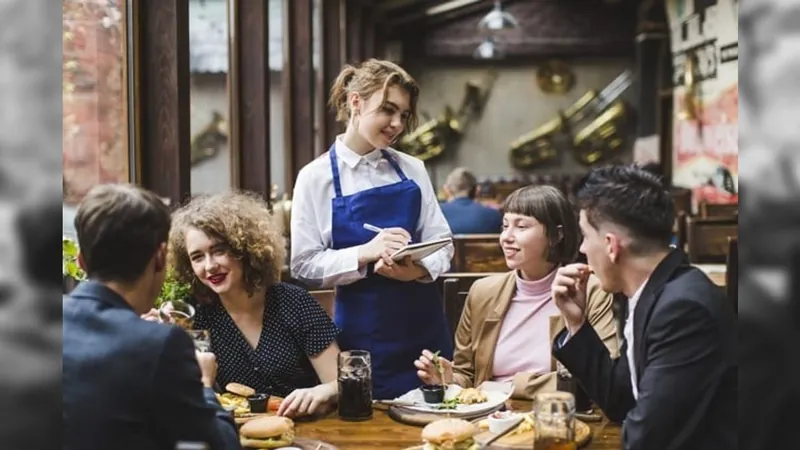 Mulher atende clientes em restaurante 