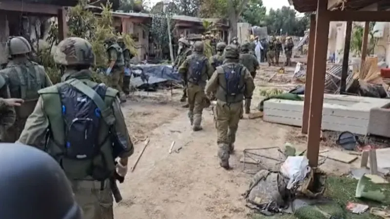 Soldados israelenses retiram corpos em Kfar Aza, no sul do país