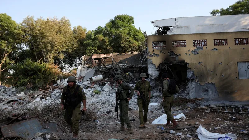 Soldados israelenses caminham após infiltração de homens armados do Hamas no Kibutz Beeri
