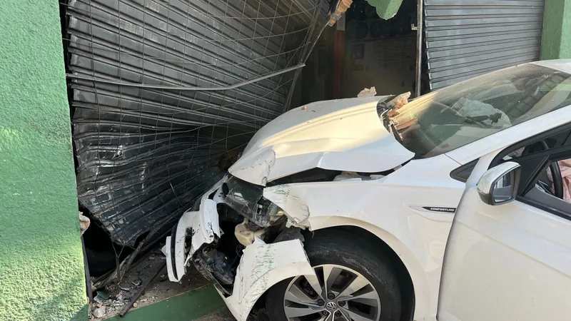 Carro bate em porta de estabelecimento comercial em Lorena