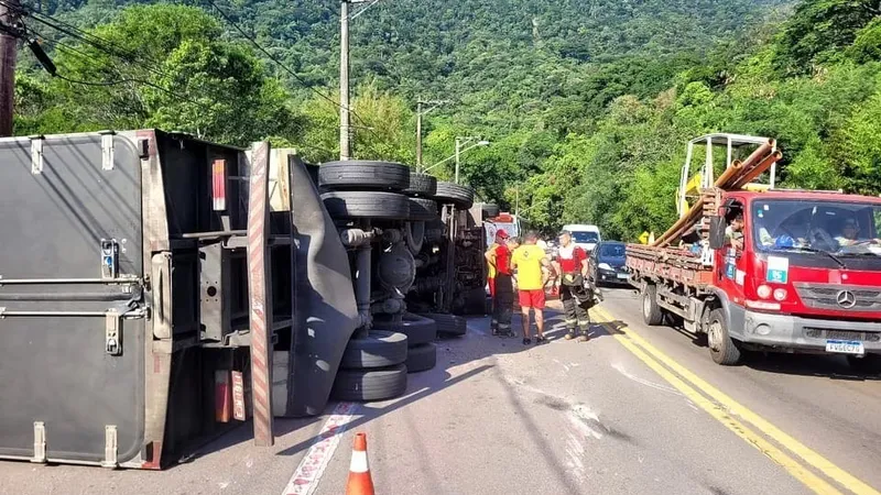 Caminhão baú tomba após bater contra ônibus em rodovia de São Sebastião