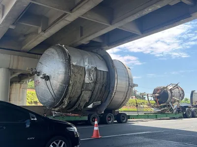 Carreta que transportava reator industrial bate em viaduto e derruba carga sobre a pista