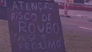 Placa na Avenida Brasil alerta motoristas sobre os riscos de roubo na via