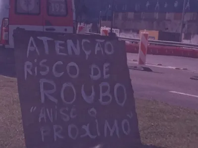 Placa na Avenida Brasil alerta motoristas sobre os riscos de roubo na via